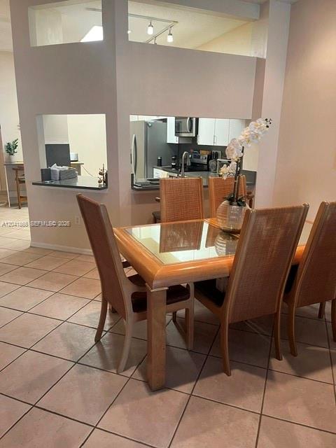 A dining area features a wooden table with cane-back chairs on a tiled floor — 10136 Lombardy Dr, Tamarac FL 33321, TAMARAC, FL
