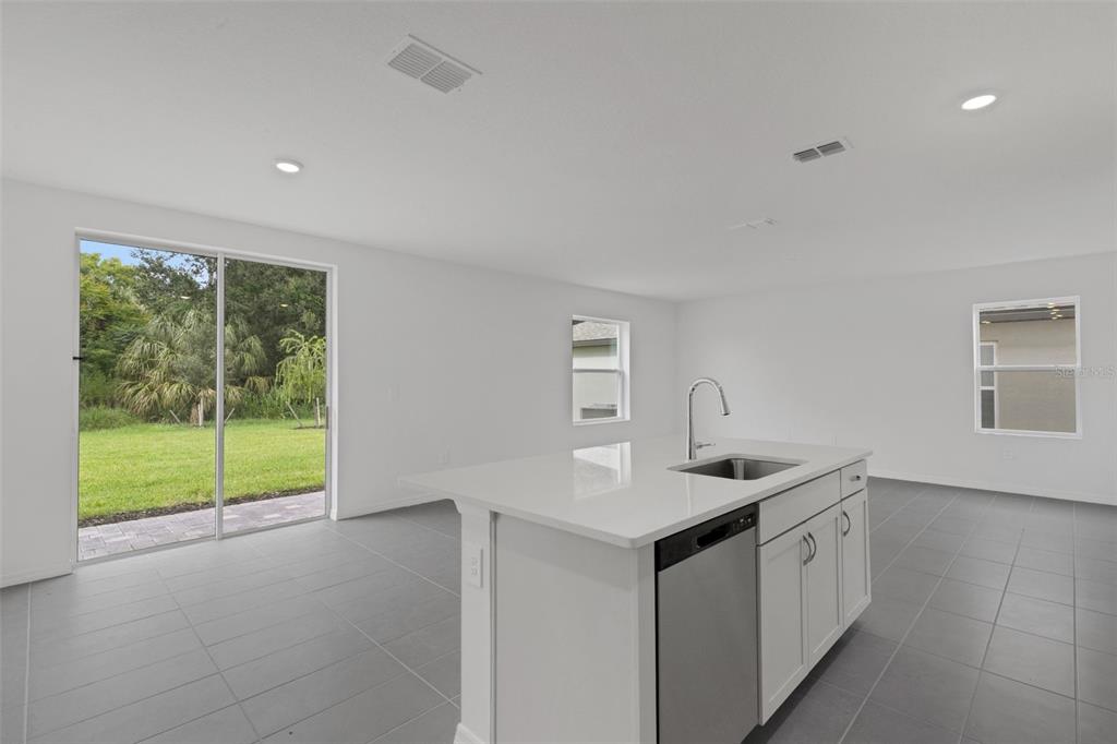 A kitchen island with a sink and dishwasher sits in a room with tiled floors — 4328 OUTHAUL RUN, PALMETTO, FL