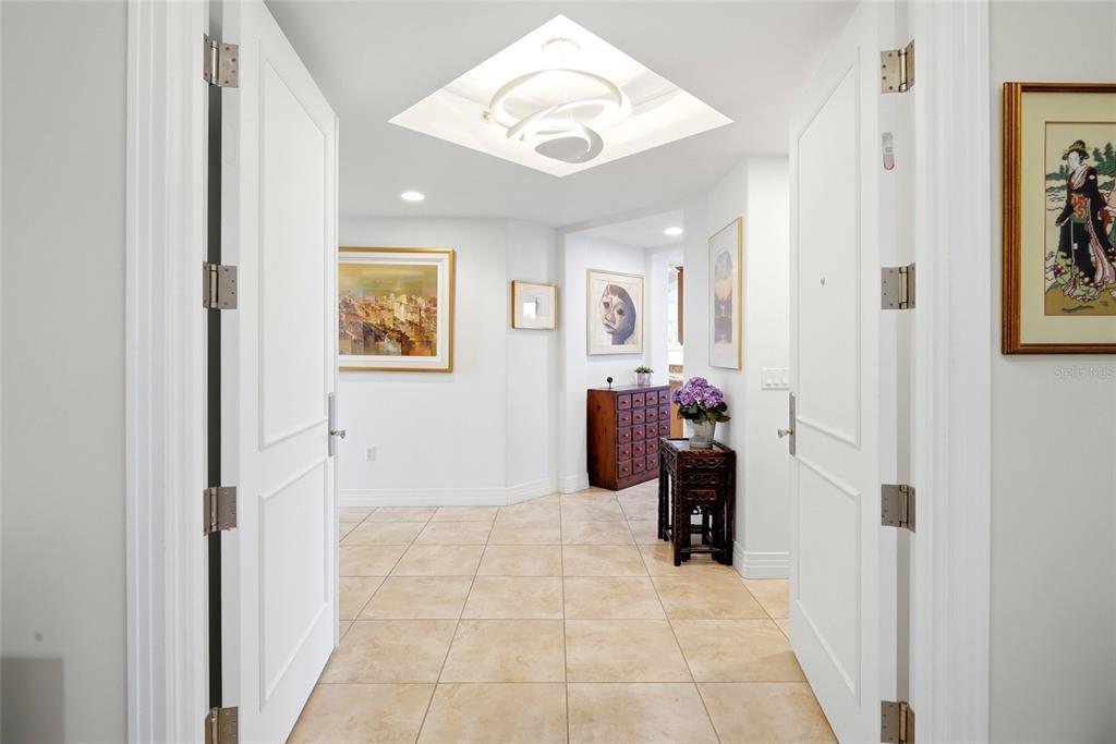 A bright entryway features white double doors, tiled flooring, and several framed artworks on walls — 400 BEACH DRIVE NE UNIT 401, ST PETERSBURG, FL