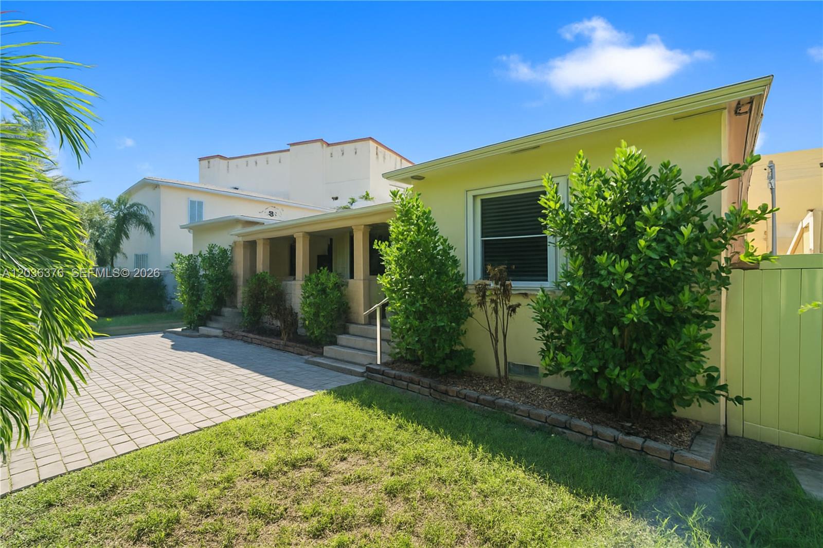 A yellow house features a paved driveway, a covered porch, and landscaped garden beds — 2530 SW 27th St # 2532, Miami FL 33133, MIAMI, FL