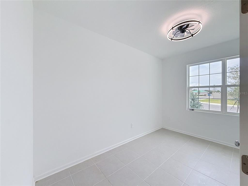 A small, empty room with white walls, light-colored tile flooring, and a ceiling fan — 3660 ROLLING RIDGE BEND, DAVENPORT, FL