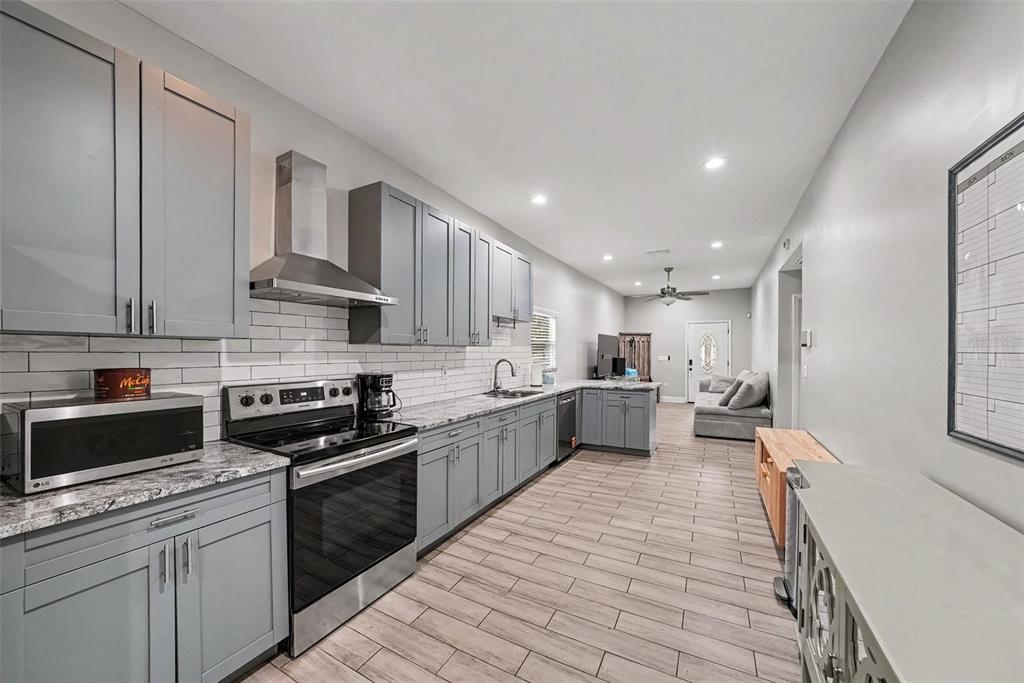 A kitchen with gray cabinets, stainless steel appliances, and wood-look tile flooring — 2341 W CHESTNUT STREET, TAMPA, FL
