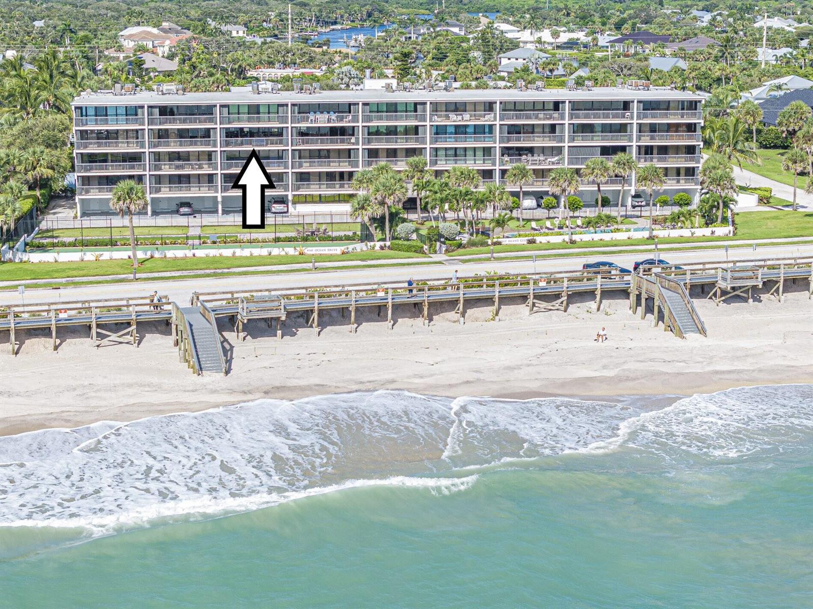 An aerial view shows a multi-story beachfront condominium building with balconies facing the ocean — 4141 Ocean Drive # 403, Vero Beach FL 32963, VERO BEACH, FL