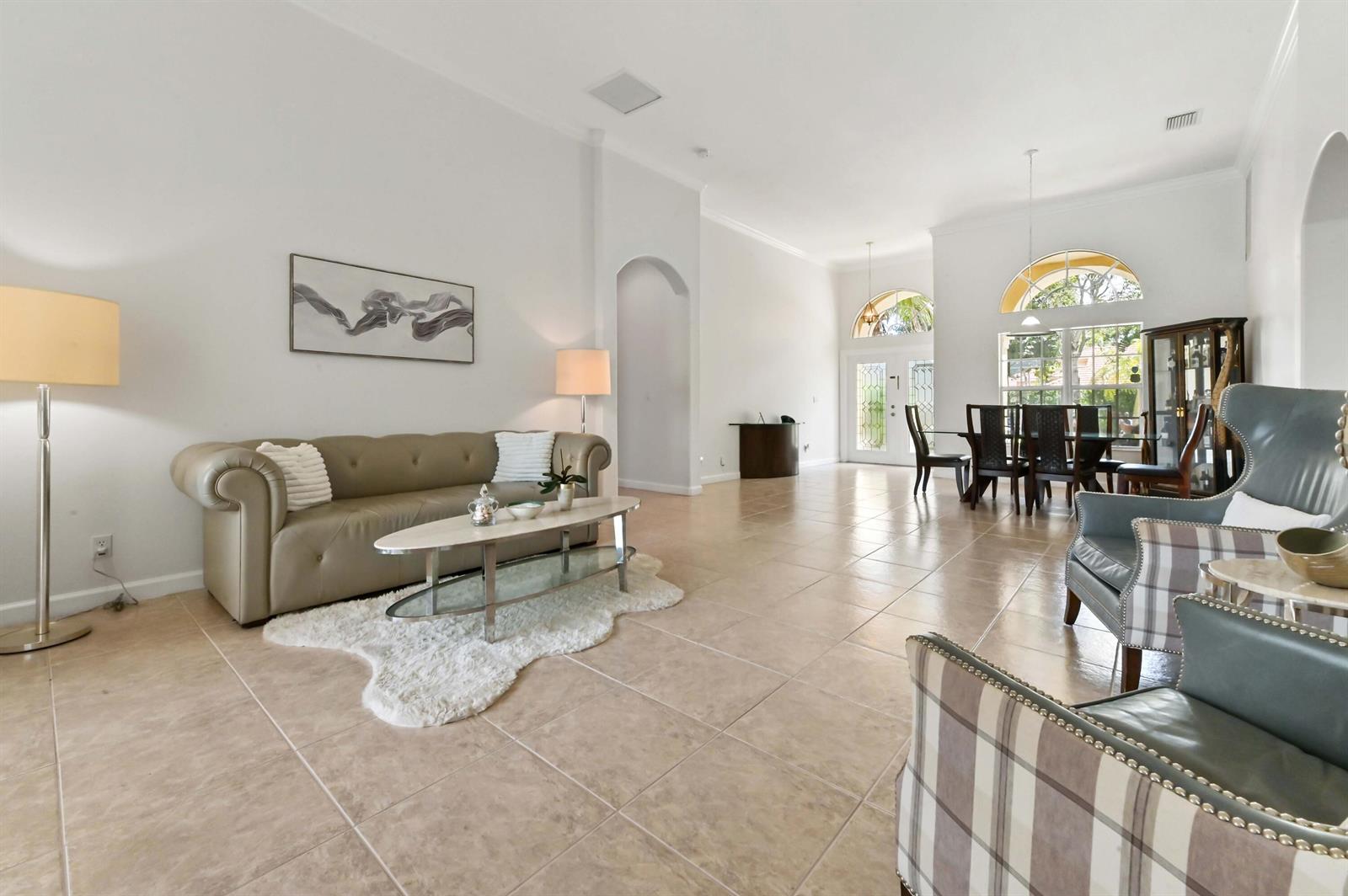 A spacious living and dining area features tile flooring, high ceilings, and neutral walls — 3638 Hamilton Key, West Palm Beach FL 33411, WEST PALM BEACH, FL