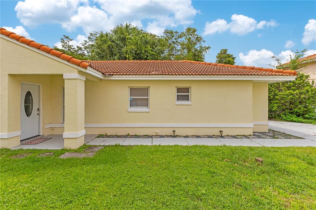 A white front door with an oval glass insert sits under a covered entryway — 2346 CORDOVA COURT, KISSIMMEE, FL
