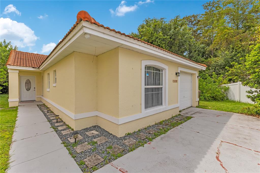 A living room features light wood-look flooring, a vaulted ceiling, and sliding glass patio doors — 2346 CORDOVA COURT, KISSIMMEE, FL