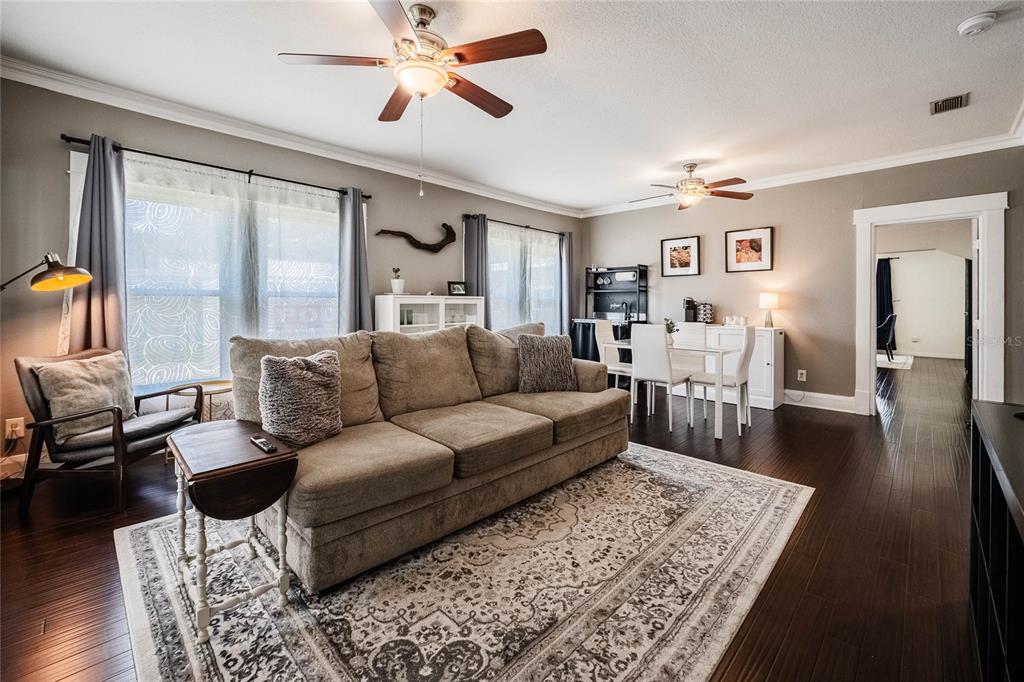 A living room features a beige sofa, dark wood floors, and a dining area — 848 VALENCIA STREET E, LAKELAND, FL