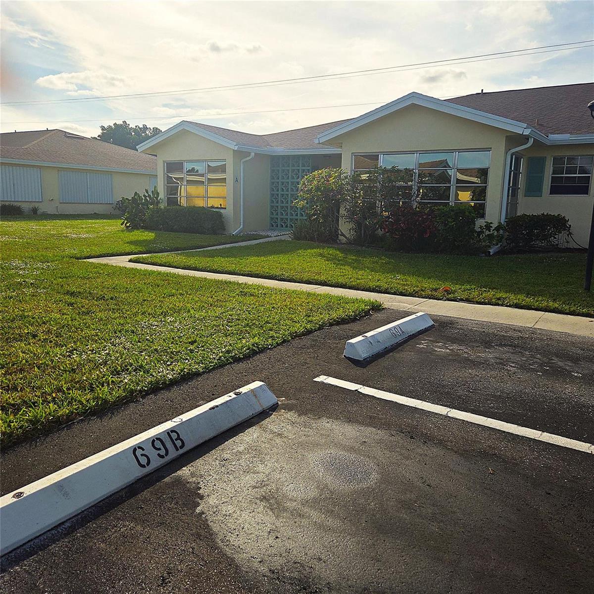 A view of a yellow single-story building with two parking spaces marked 69A and 69B — 5385 Lakefront Boulevard # A, Delray Beach FL 33484, DELRAY BEACH, FL
