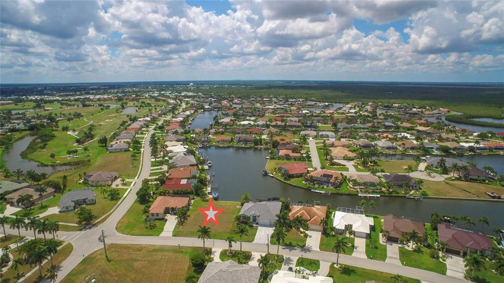 An aerial view shows a vacant waterfront residential lot marked with a red star — 507 MADRID BOULEVARD, PUNTA GORDA, FL