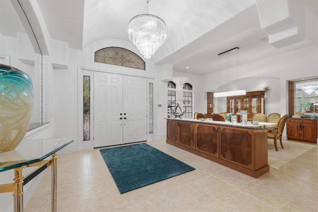 A bright foyer features a crystal chandelier, double front doors, and a wooden buffet table — 3548 FOUNDERS CLUB DRIVE, SARASOTA, FL