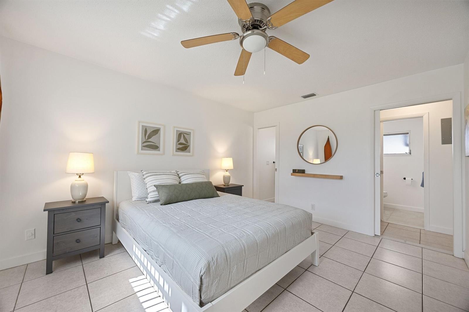 A bedroom with a white bed, gray nightstands, a ceiling fan, and tile flooring — 2691 Dudley Dr Drive E # D, West Palm Beach FL 33415, WEST PALM BEACH, FL