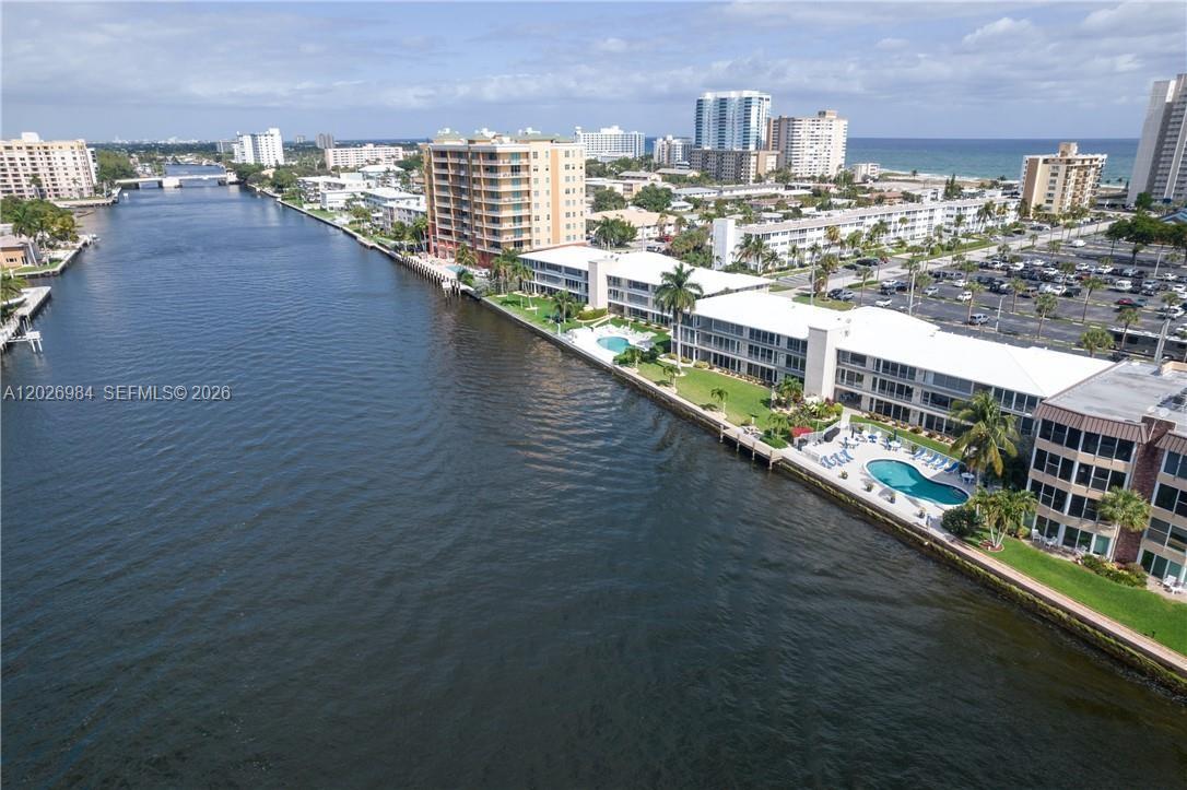 An aerial view shows a waterway alongside apartment buildings with swimming pools and parking lots — 743 N Riverside Dr # 4B, Pompano Beach FL 33062, POMPANO BEACH, FL