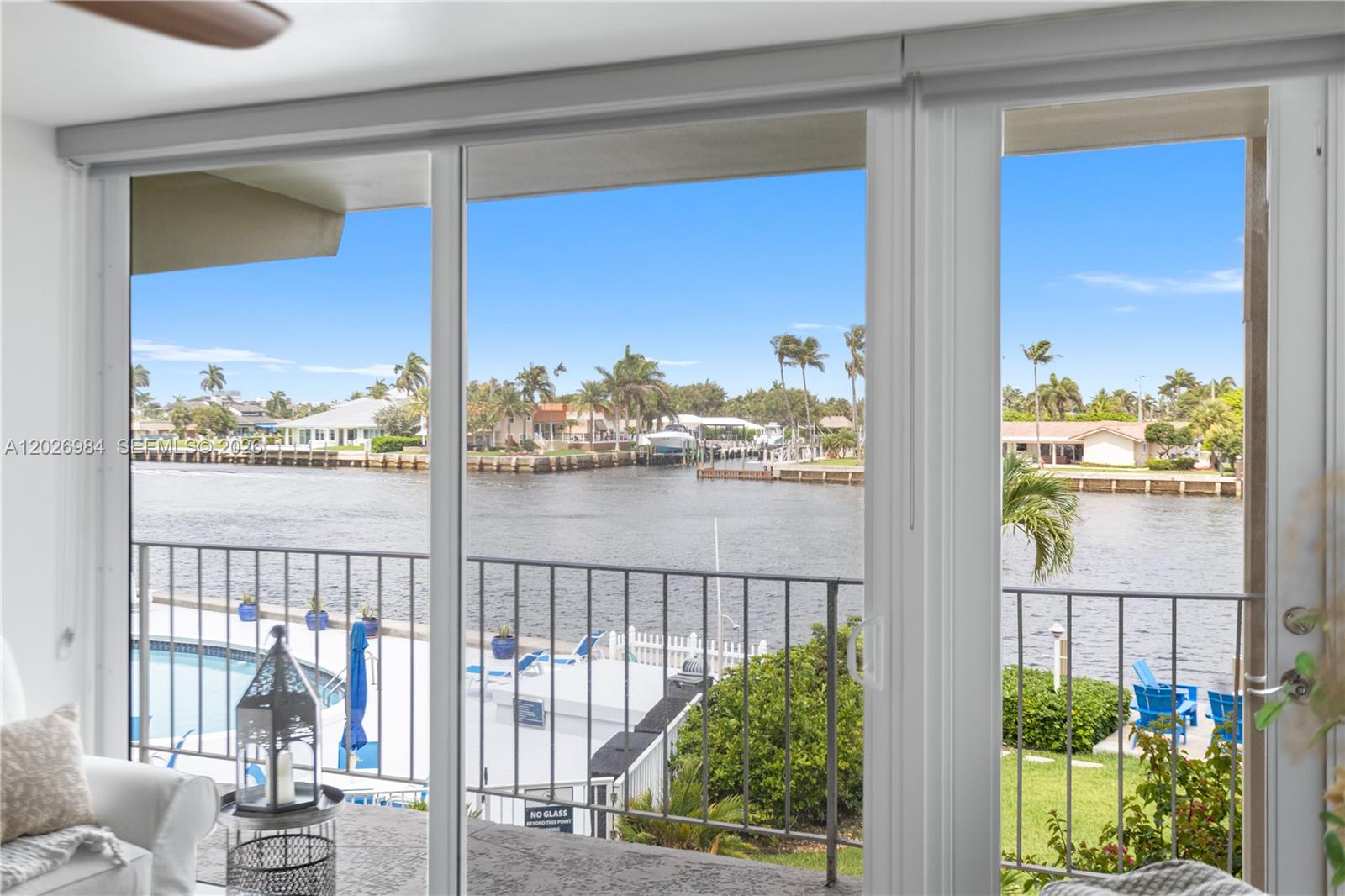 A view of a waterfront canal and pool from inside a room through sliding doors — 743 N Riverside Dr # 4B, Pompano Beach FL 33062, POMPANO BEACH, FL