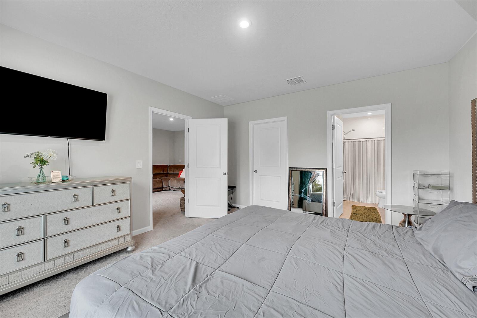 A bedroom features a gray bed, a mirrored dresser, and two doorways leading to other rooms — 333 Raspberry Road, Fort Pierce FL 34981, FORT PIERCE, FL