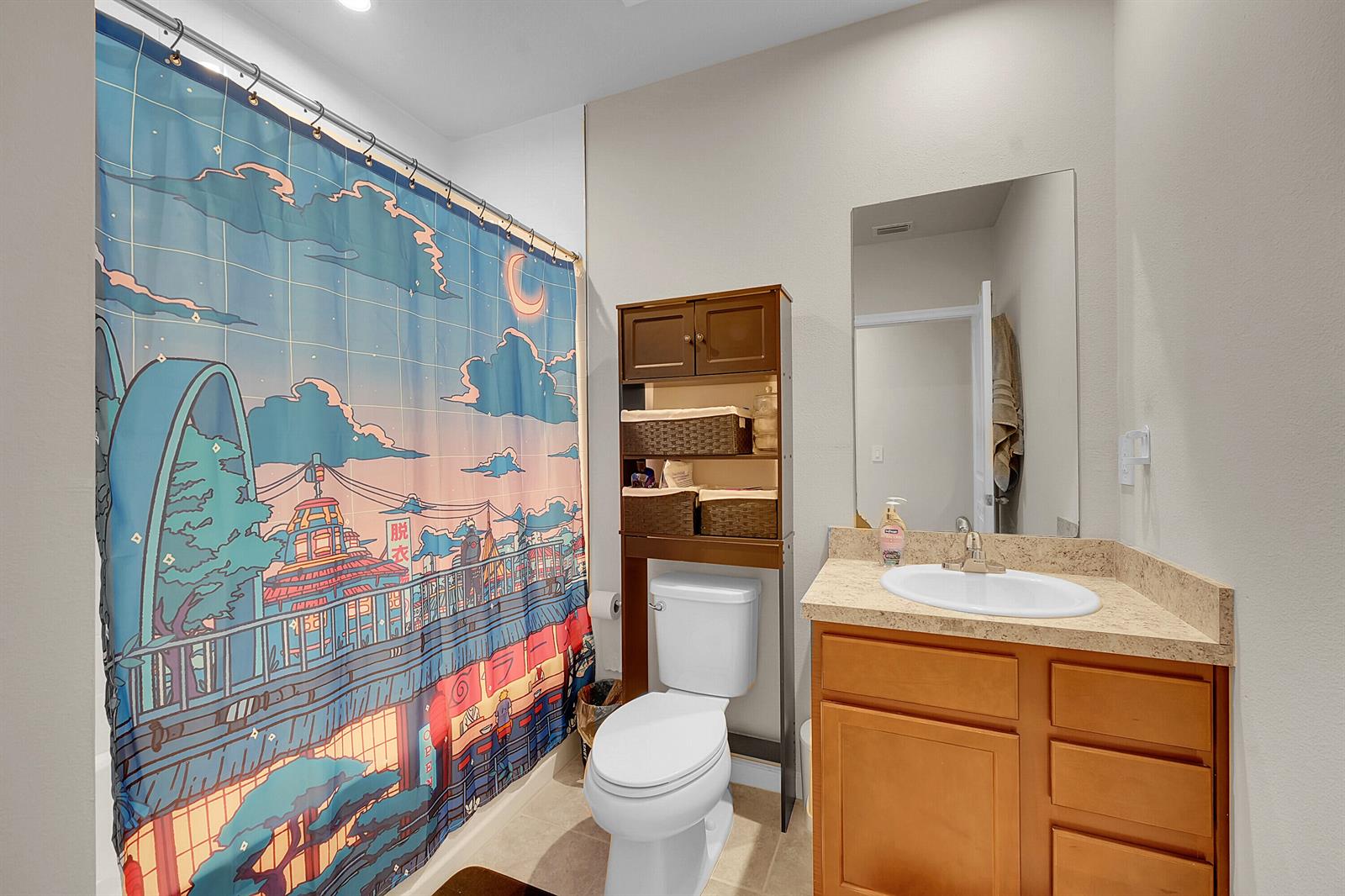 A bathroom features a vanity with a beige countertop, a toilet, and an anime-themed shower curtain — 333 Raspberry Road, Fort Pierce FL 34981, FORT PIERCE, FL