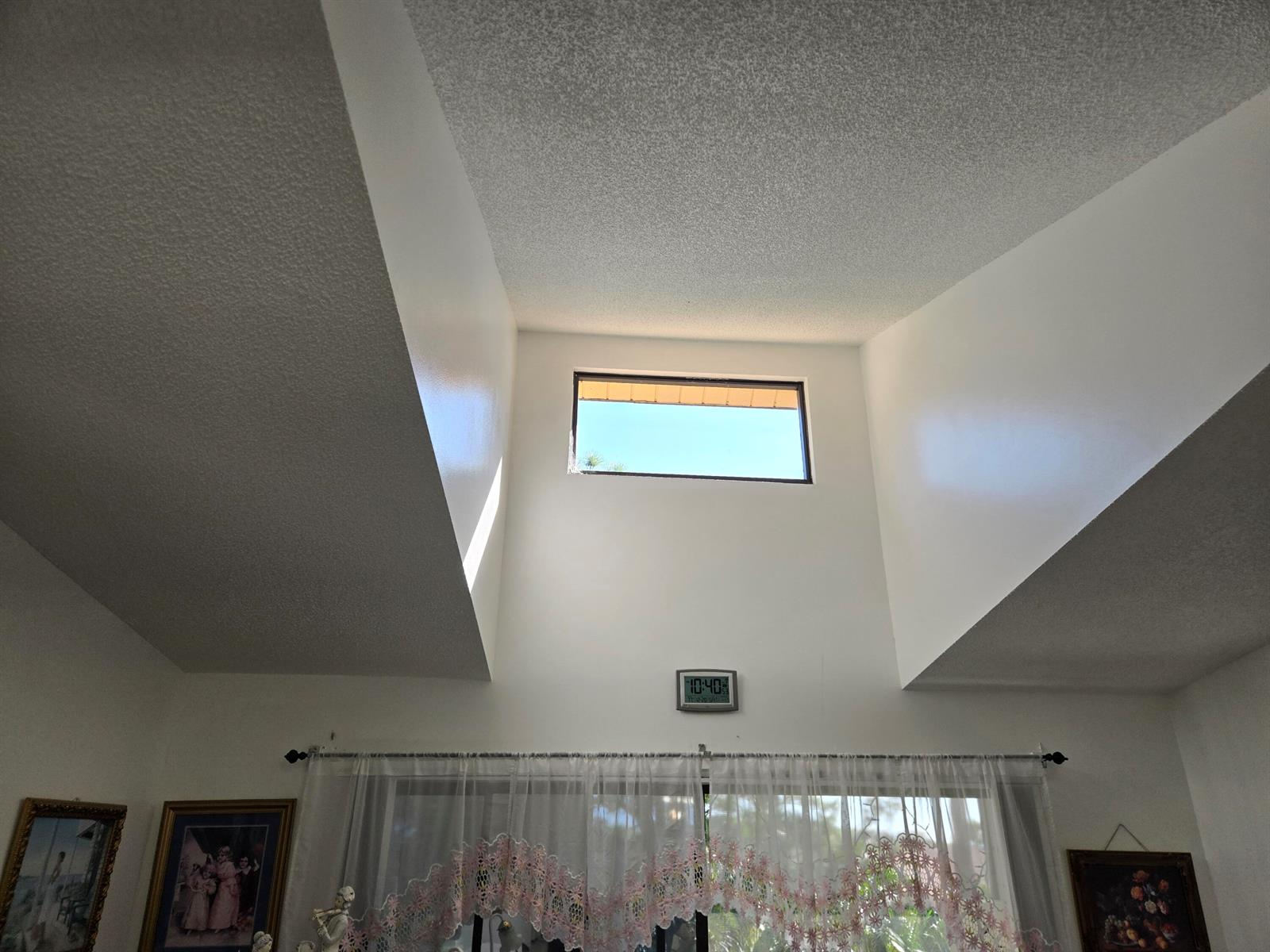 A high-ceilinged room features a small rectangular clerestory window above a sliding glass door — 819 Sky Pine Way # G3, FL 33415, FL