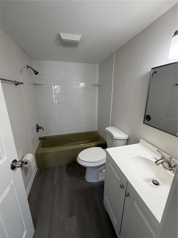 A bathroom features a white vanity, a toilet, and a tub with olive-colored tile surround — 21287 GERTRUDE AVENUE UNIT 208, PORT CHARLOTTE, FL