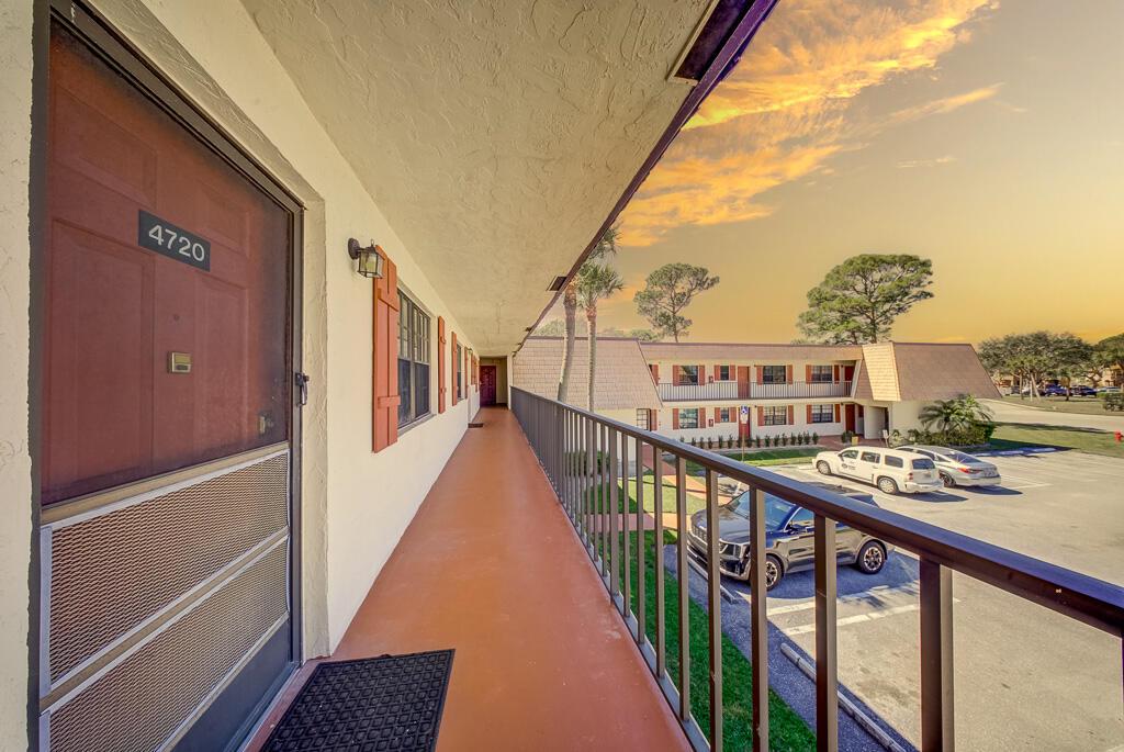 An exterior walkway with a metal railing overlooks a parking lot at an apartment complex — 4720 Oak Terrace Drive, FL 33463, FL