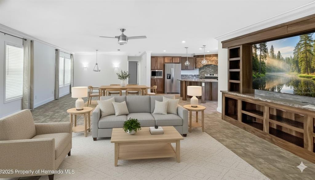 This open-concept living and dining area features a large entertainment center and a kitchen island — 9896 SCEPTER AVENUE, BROOKSVILLE, FL