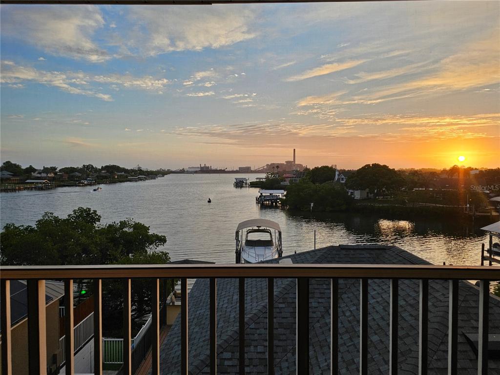 A balcony view overlooks a waterway with boats, docks, and a sunset on the horizon — 1209 APOLLO BEACH BOULEVARD, APOLLO BEACH, FL