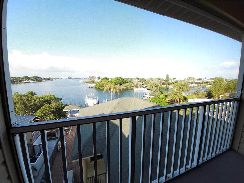 A screened balcony overlooks a waterway with boats, docks, and surrounding residential properties — 1209 APOLLO BEACH BOULEVARD, APOLLO BEACH, FL