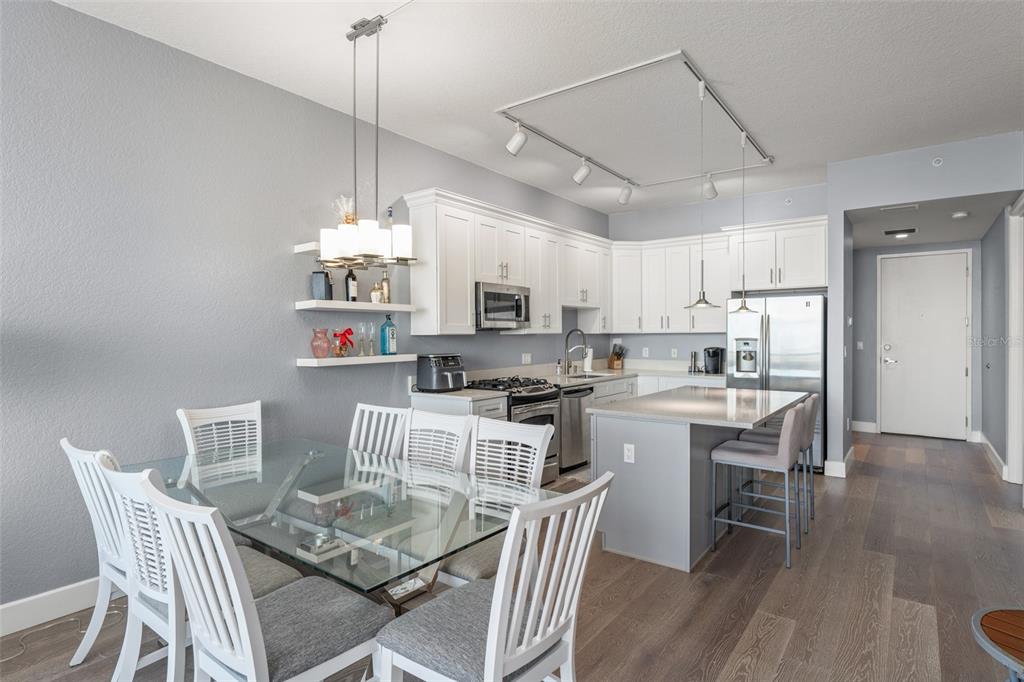 A modern kitchen with white cabinets, a glass dining table, and a gray kitchen island — 150 E ROBINSON STREET UNIT 2008, ORLANDO, FL