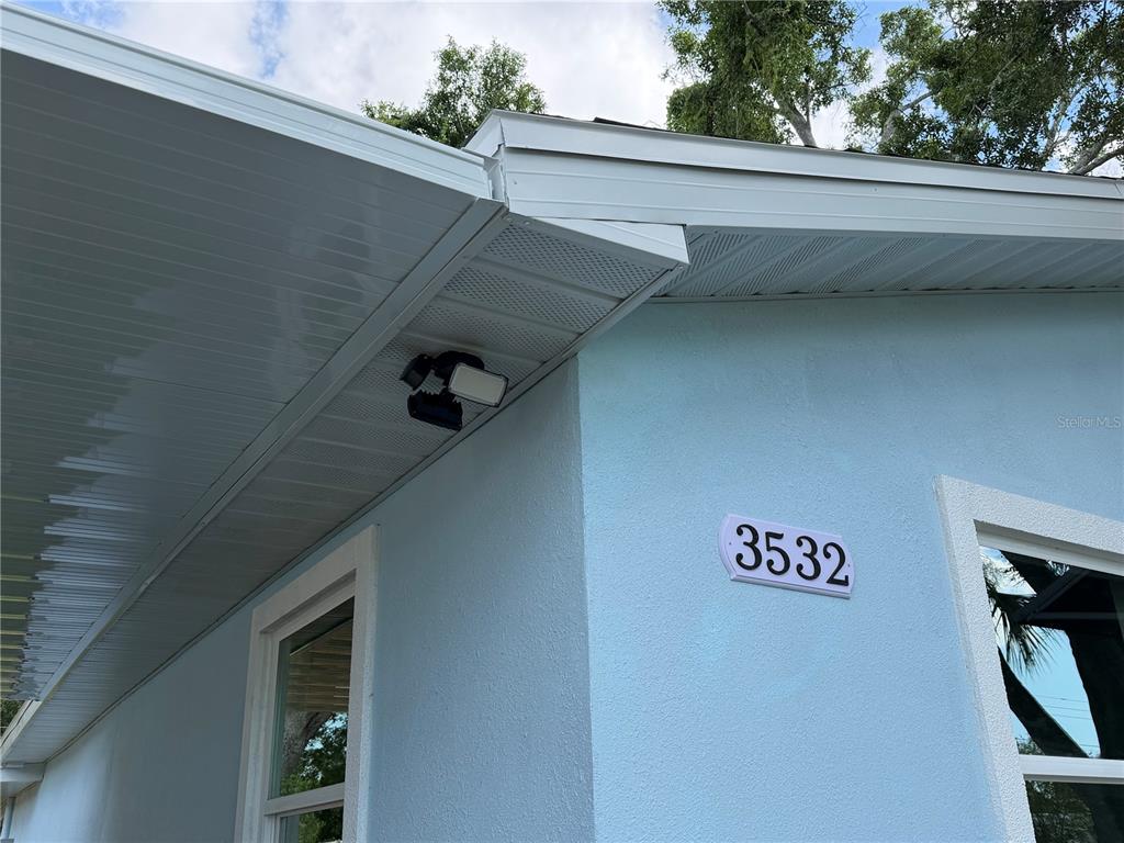 A light blue house exterior features a dark blue front door and a small porch — 3532 76TH TERRACE N, PINELLAS PARK, FL