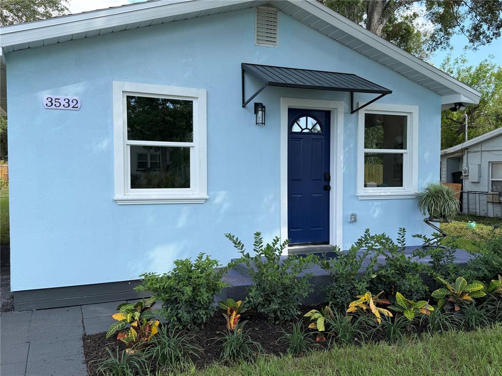 A light blue exterior wall features a house number, a window, and a soffit light — 3532 76TH TERRACE N, PINELLAS PARK, FL