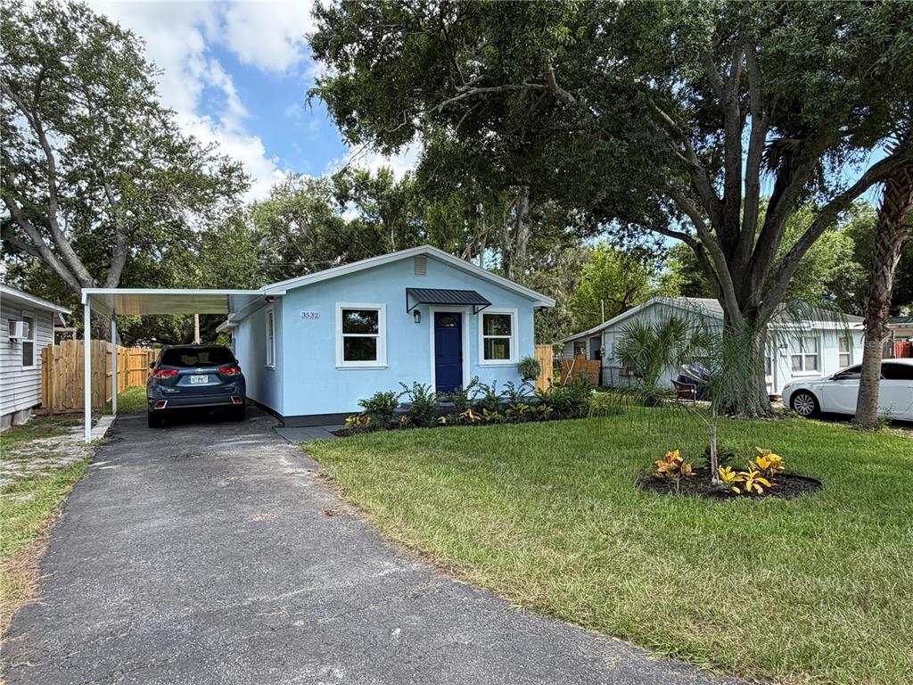 A light blue house with a dark blue front door and a large front yard — 3532 76TH TERRACE N, PINELLAS PARK, FL