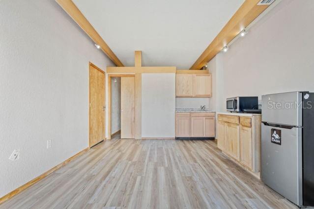 A small kitchen area features light wood cabinets, a microwave, and a stainless steel refrigerator — 101 PALM HARBOR PARKWAY UNIT C231- B, PALM COAST, FL