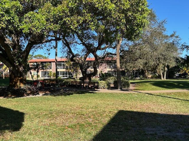 A multi-story apartment building is viewed across a grassy lawn shaded by large trees — 1925 SW Palm City Road # A, Stuart FL 34994, STUART, FL