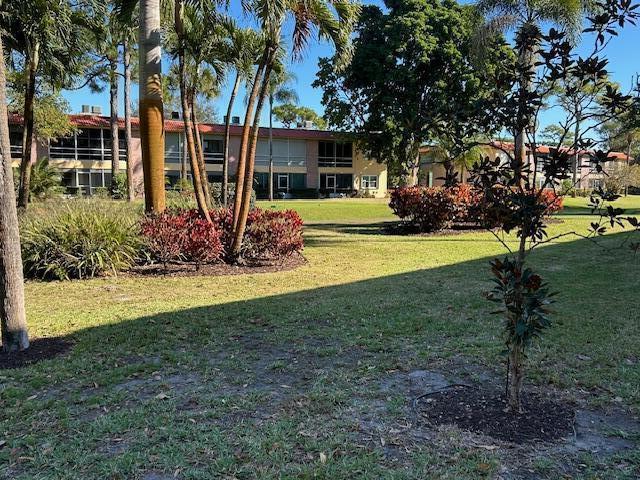 A multi-story apartment building sits behind a grassy lawn with palm trees and shrubs — 1925 SW Palm City Road # A, Stuart FL 34994, STUART, FL