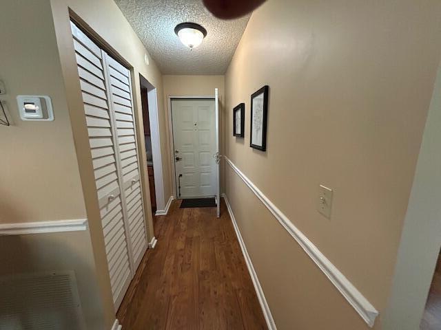 A hallway features wood-look flooring, beige walls with chair rail molding, and a white door — 1925 SW Palm City Road # A, Stuart FL 34994, STUART, FL