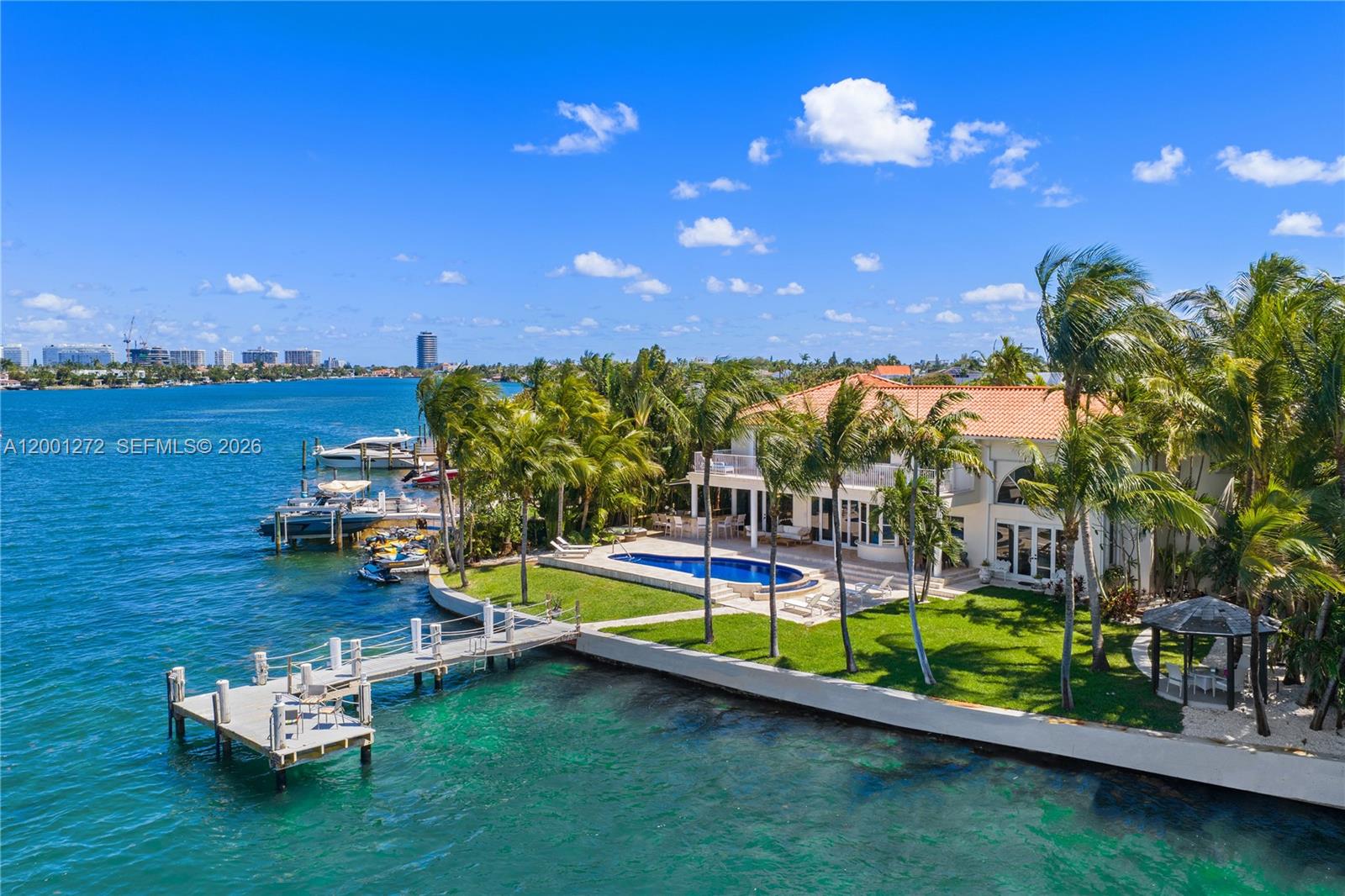 An aerial view of a waterfront house with a pool, dock, and palm trees — 1575 Stillwater Dr, Miami Beach FL 33141, MIAMI BEACH, FL