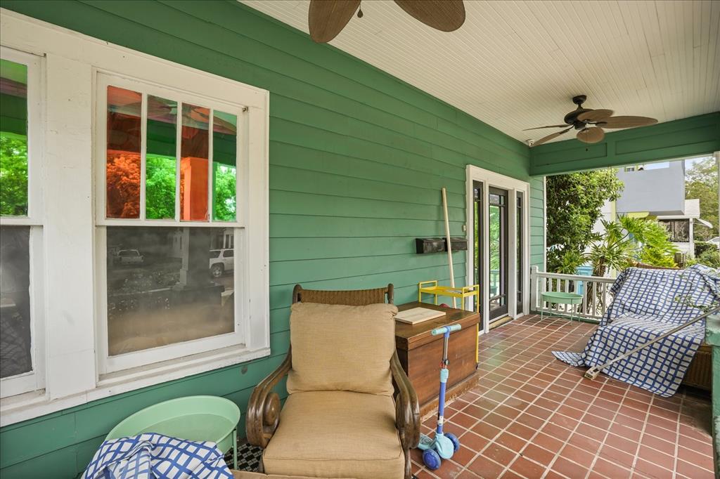 A covered porch with green siding, tiled flooring, a ceiling fan, and outdoor furniture — 1629 FERRIS AVENUE, ORLANDO, FL