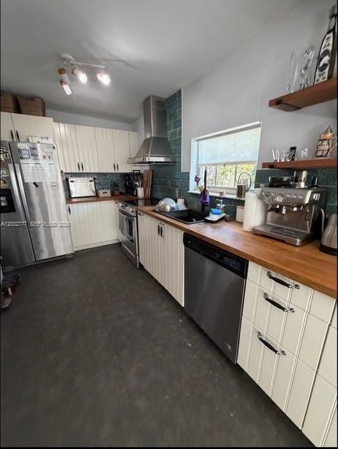 A kitchen with white cabinets, a stainless steel refrigerator, a wooden countertop, and teal backsplash — 3685 SW 1st Ave, Miami FL 33145, MIAMI, FL
