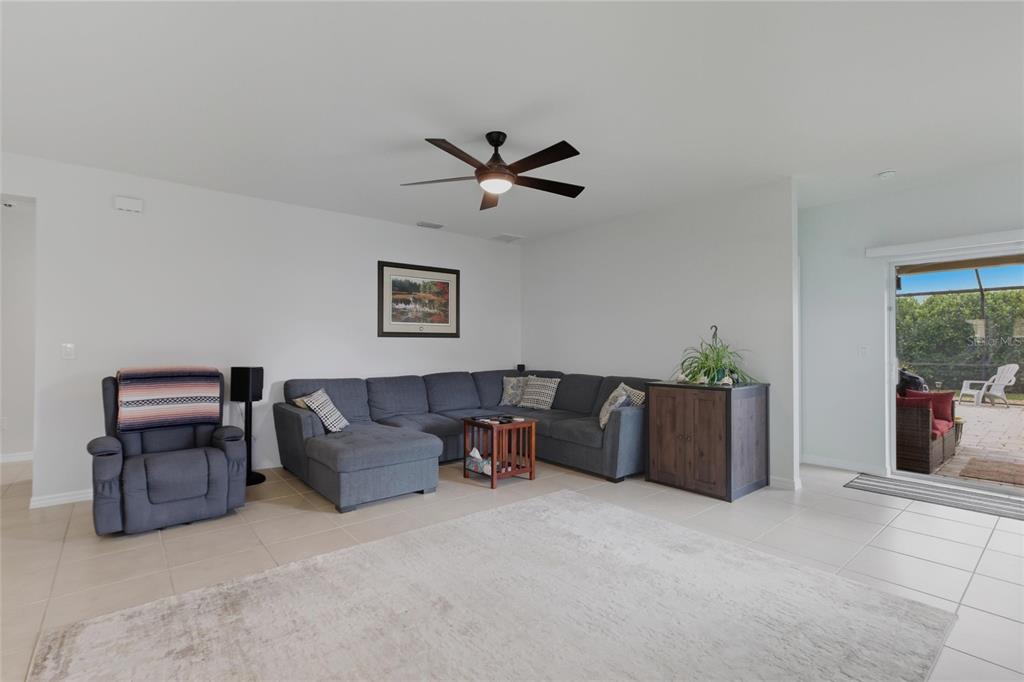 A living room features a gray sectional sofa, a matching recliner, and a sliding glass door — 314 SE VAN LOON TERRACE, CAPE CORAL, FL