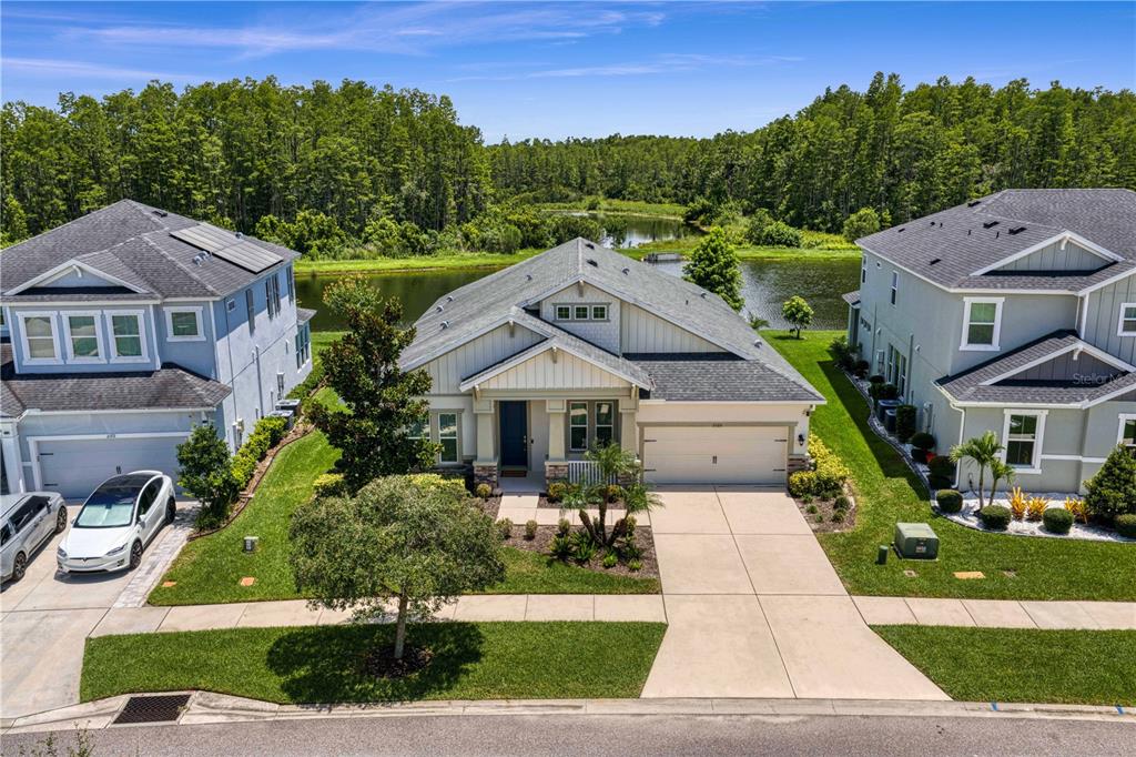 An aerial view shows a single-story house with a garage situated between two neighboring homes — 2160 SECRET COVE, ODESSA, FL