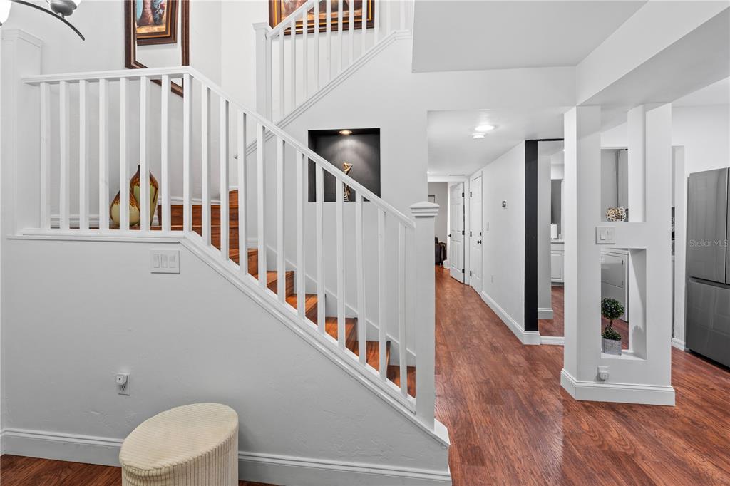 A white staircase with wooden steps leads to an upper level near a hallway — 1215 NW 55TH STREET NW UNIT 7, GAINESVILLE, FL
