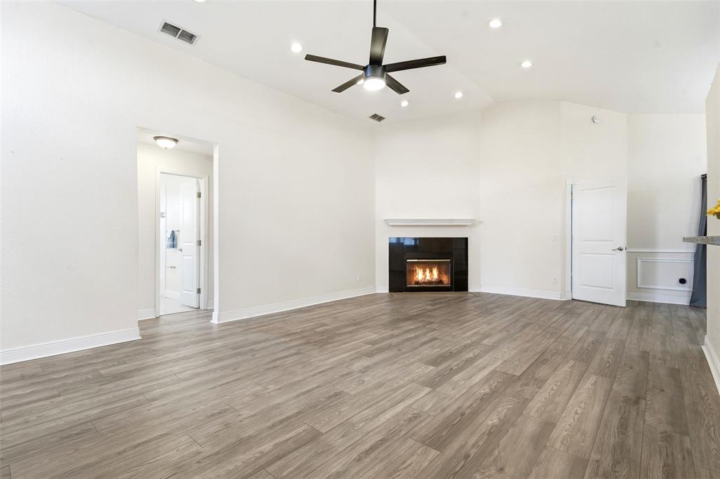 A living room features light wood-look flooring, a fireplace with a black surround, and recessed lighting — 1238 COURTLAND BOULEVARD, DELTONA, FL
