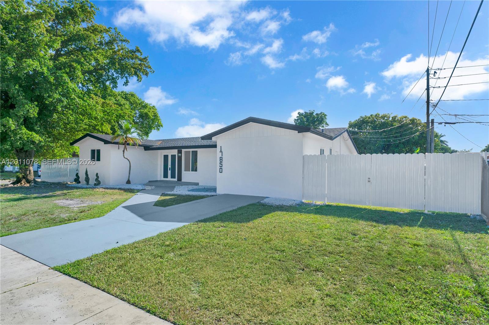 A white single-story house with a concrete driveway and a white privacy fence — 17850 SW 112th Ave, Miami FL 33157, MIAMI, FL