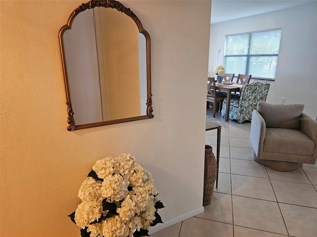 An arched mirror hangs on a wall above a large bouquet of white flowers — 4214 EL DORADO COVE UNIT V-10, BRADENTON, FL