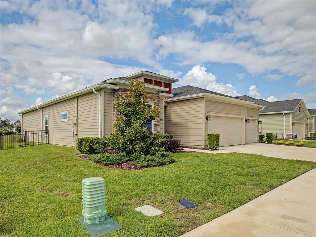 A single-story house with tan siding, a stone facade, and a two-car garage — 7672 SW 74TH LOOP, OCALA, FL