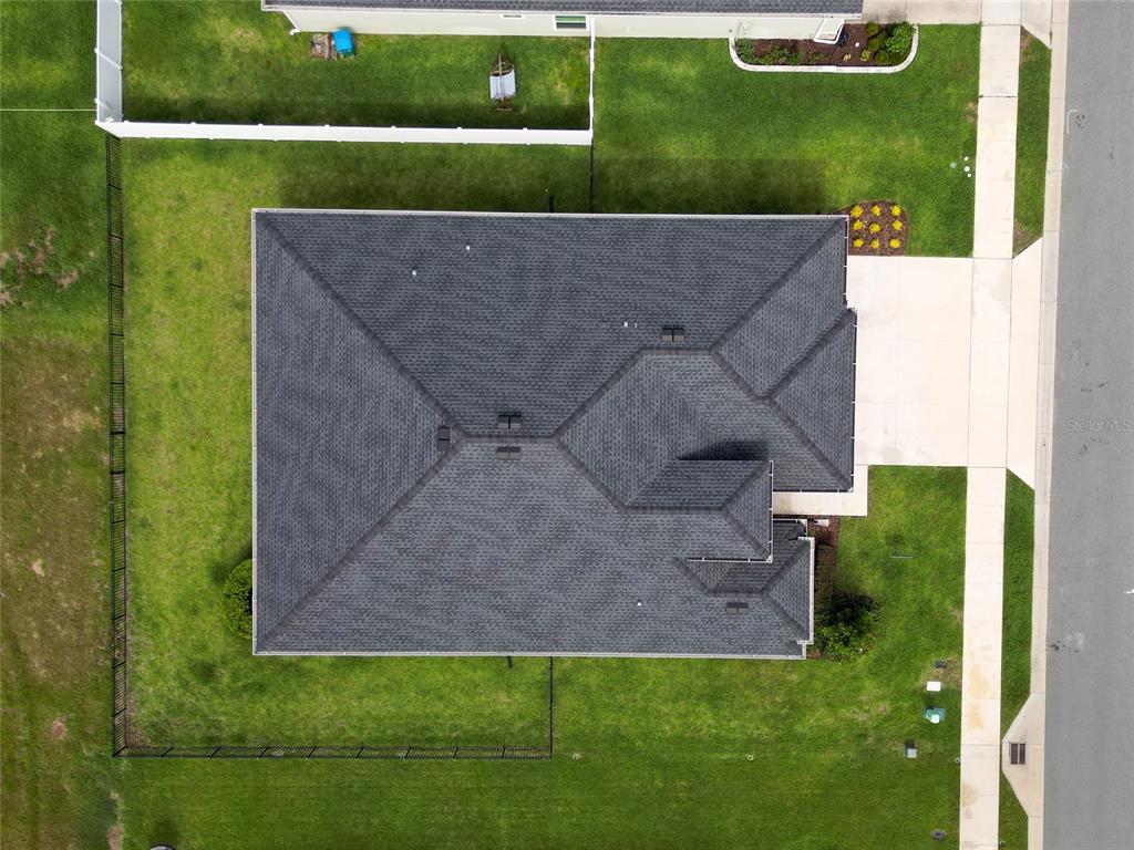 An aerial view shows a residential house with a dark shingled roof and fenced yard — 7672 SW 74TH LOOP, OCALA, FL