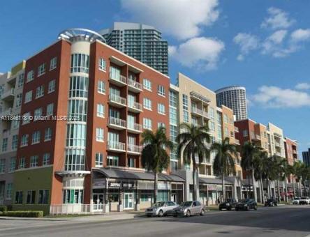 A multi-story apartment building with red brick facades, balconies, and ground-floor retail spaces — 2000 N Bayshore Dr # 122, Miami FL 33137, MIAMI, FL