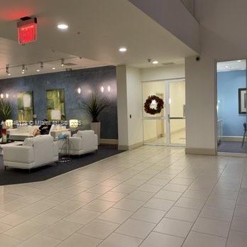 A modern lobby features white lounge seating, a dark accent wall, and glass entry doors — 2000 N Bayshore Dr # 122, Miami FL 33137, MIAMI, FL