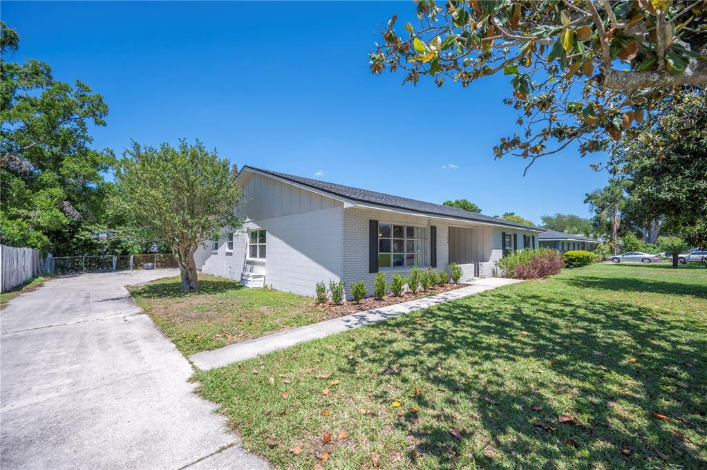 A white brick house with a concrete driveway and a large front lawn — 1308 GLENFORD LANE, LAKELAND, FL