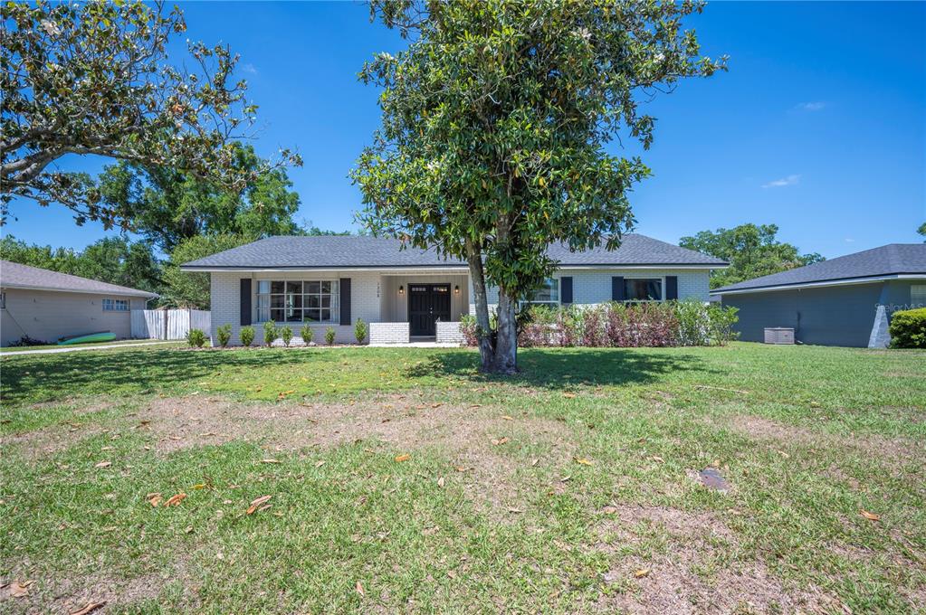 A single-story brick house with a large front yard and a prominent tree — 1308 GLENFORD LANE, LAKELAND, FL