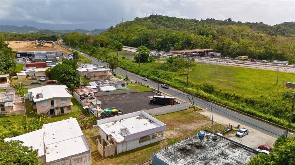 An aerial view shows a residential area with several buildings near a highway and tollbooth — BO CATANO LOT #1 CARR 3 KM 85.9, HUMACAO, PR