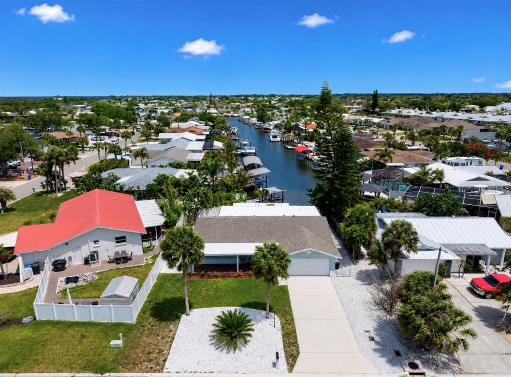 An aerial view shows a residential street with houses, a canal, and boats — 6513 ABACO DRIVE, APOLLO BEACH, FL